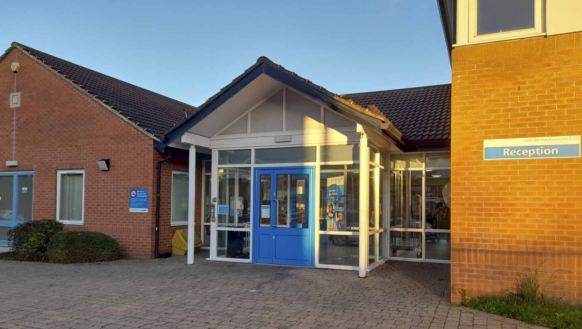 An exterior photo of a blue door and a hospital reception