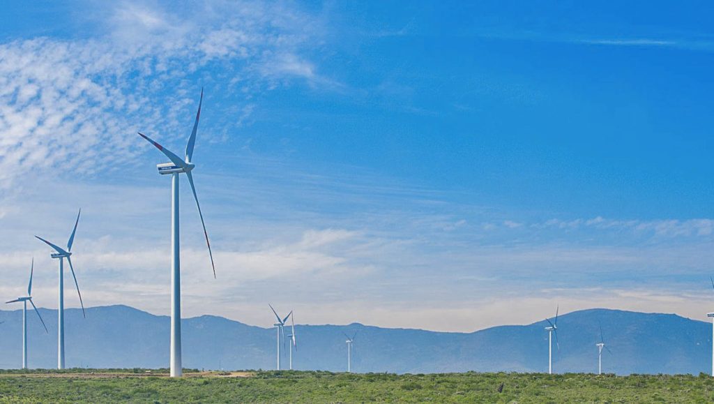 Landscape photo of a wind farm with mountains in the background