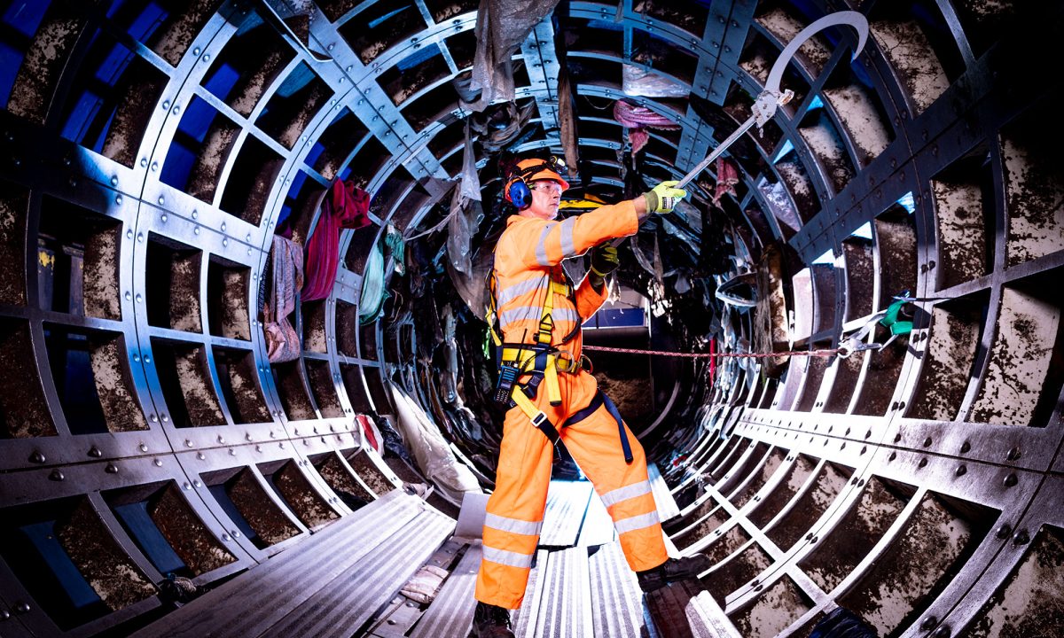 A man working on the interior of an underground steel tunnel